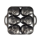 Lodge black cake mold with six skull-shaped cavities for baking creative skull-themed desserts.