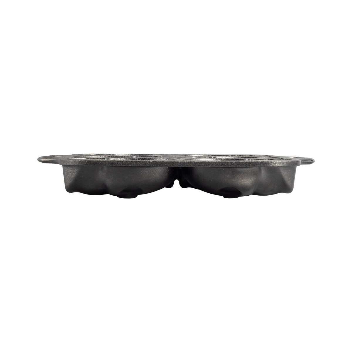 Lodge black cake pan with six skull-shaped molds for baking themed desserts, made of durable material.