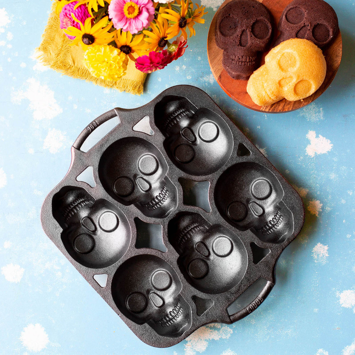 Lodge classic black cake pan with six skull-shaped molds, perfect for creative baking and themed desserts.
