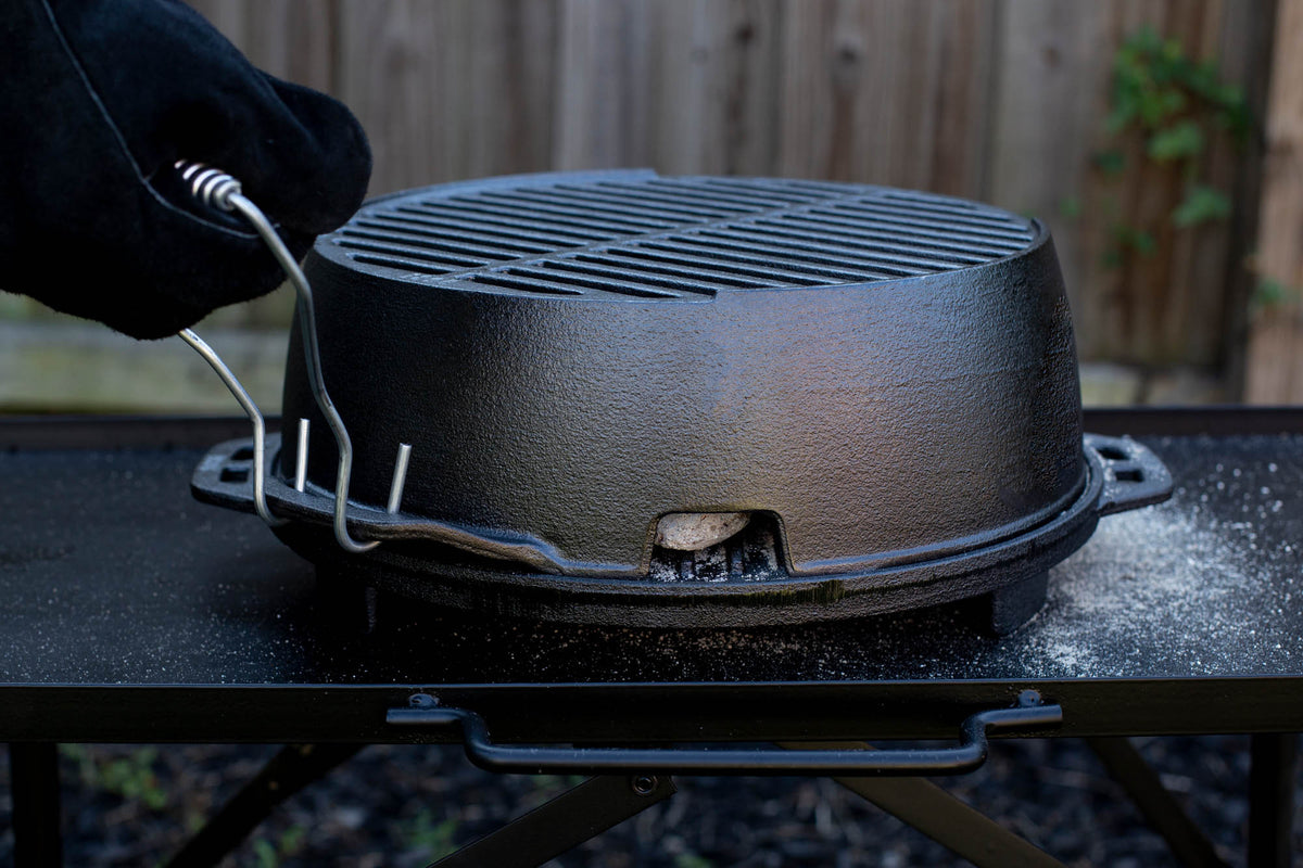 Lodge black 30.5 cm cast iron grill with ridged cooking surface, ideal for outdoor grilling and searing.