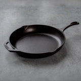Black Lodge Chef cast iron pan with handle, sturdy cooking surface, and textured exterior for versatile kitchen use.