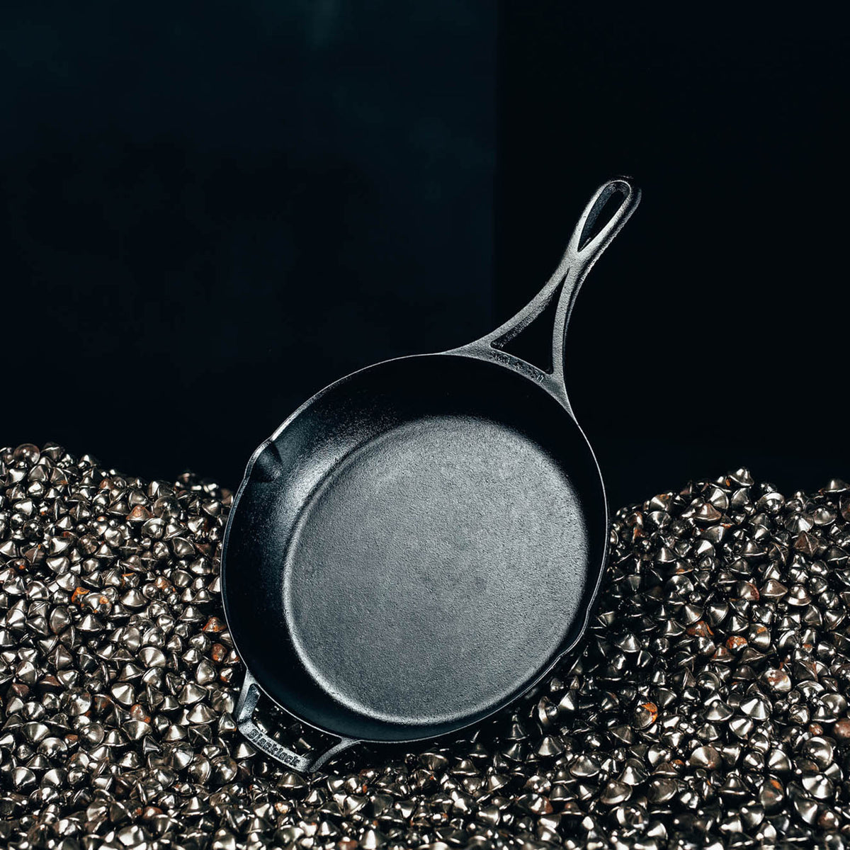 Lodge black cast iron skillet pan with 26 cm diameter, sturdy handle, suitable for stovetop cooking and versatile kitchen use.
