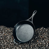 Lodge black cast iron skillet pan with 26 cm diameter, sturdy handle, suitable for stovetop cooking and versatile kitchen use.