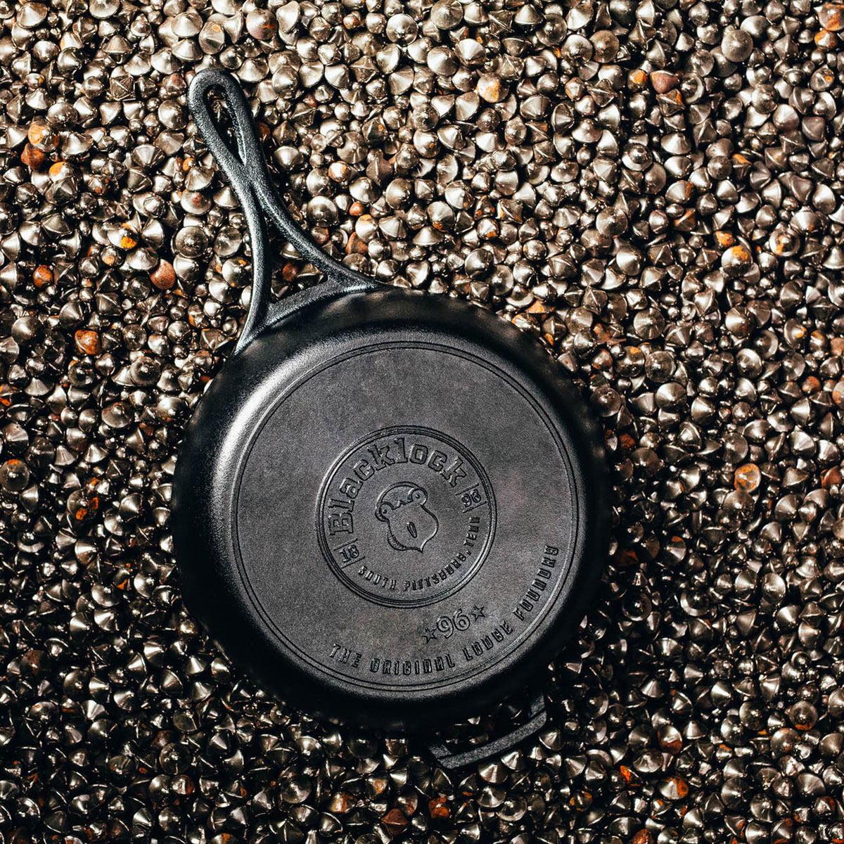 Lodge black 26cm cast iron skillet pan with black lock handle, shown from a top view.