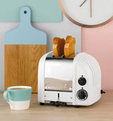 Dualit NewGen white 2-slice toaster with sleek design and control dials, perfect for toasting bread and bagels.