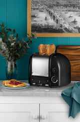 Dualit Newgen black 2-slice toaster with modern design and control knobs, ideal for toasting bread and bagels.