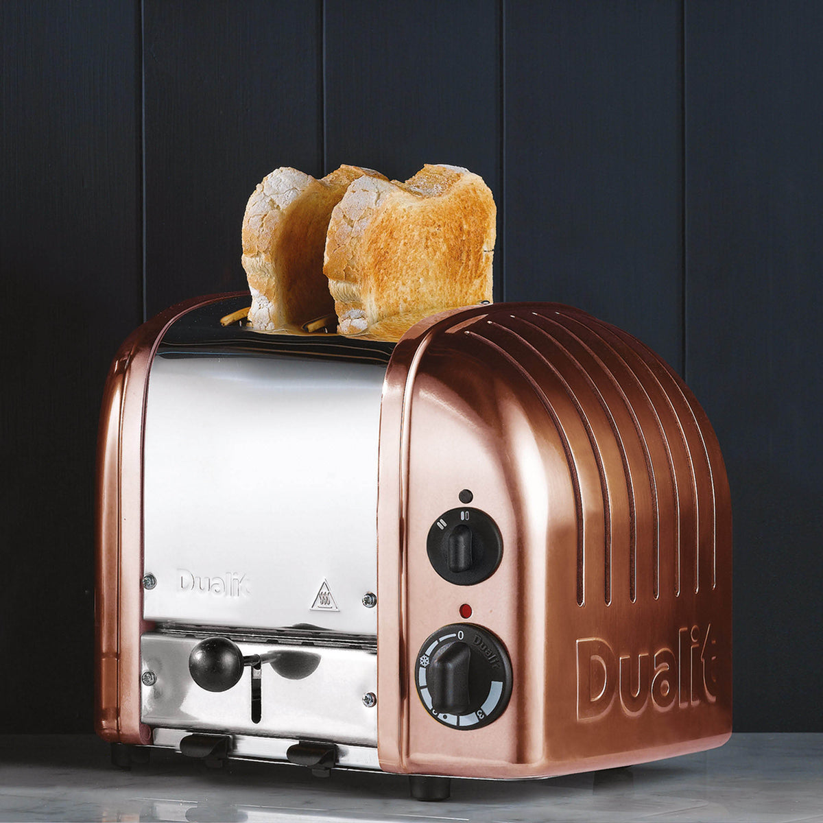Dualit NewGen copper toaster with two slots for bread, featuring a sleek modern design and adjustable browning control.