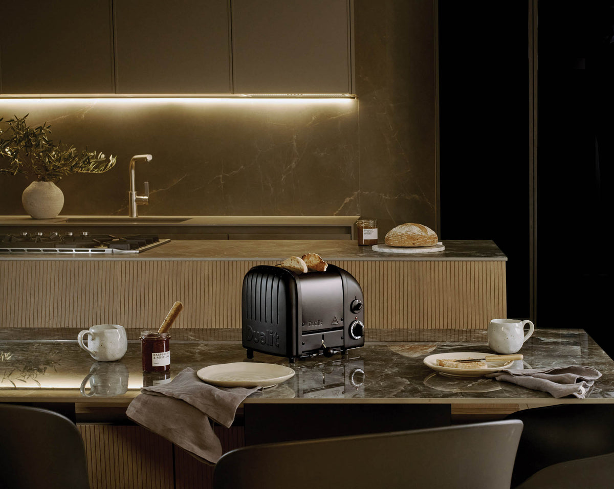 Dualit Newgen black 2-slice toaster with modern design and control knobs, perfect for toasting bread and bagels.