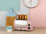 Dualit Newgen pink 4-slice toaster with modern design, featuring bread slots and control dials for easy toasting.