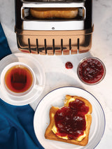 Dualit Newgen copper 4-slice toaster with modern design and control buttons, ideal for toasting bread and bagels.