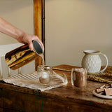 Dualit Milchaufschäumer in kupfer for frothing milk and chocolate, with sleek design and stainless steel construction.