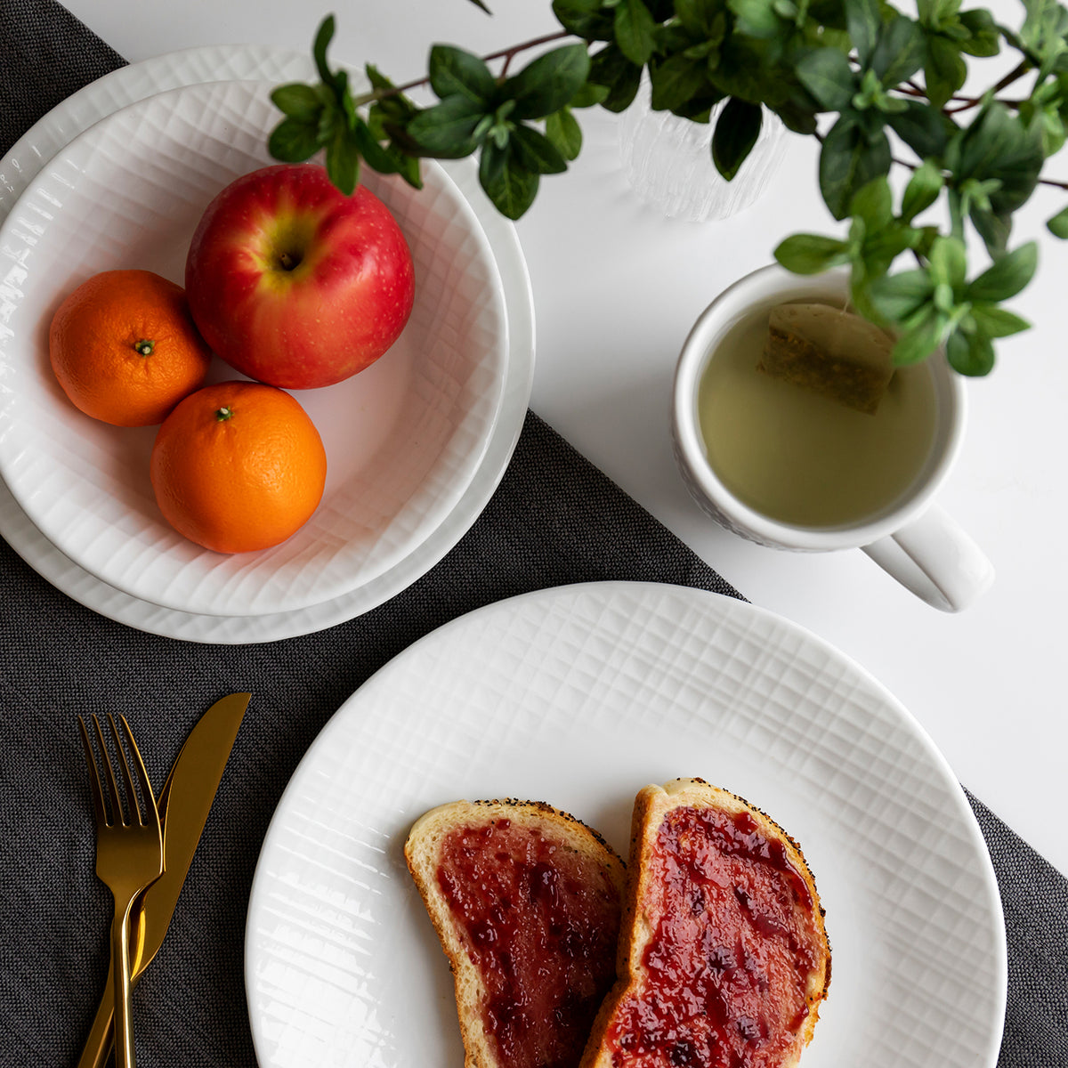 Corelle Linen Weave white dinnerware service set with plates and bowls arranged on a table.