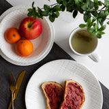 Corelle Linen Weave white dinnerware service set with plates and bowls arranged on a table.