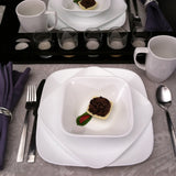 Corelle Pure White dinner service set with white plates, bowls, and cups, showcasing a clean, minimalist design.
