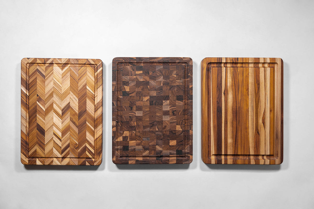 Teakhaus teak wood butcher block cutting board with knife marks and natural wood grain for kitchen use.