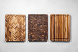 Teakhaus teak wood butcher block cutting board with knife marks and natural wood grain for kitchen use.