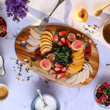 Oval TEAKHAUS teak wood cutting board with smooth surface and natural wood grain for kitchen use