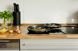 Black KYOCERA ceramic frying pan with non-stick surface, showcasing a smooth cooking surface and durable handle.