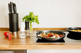 Kyocera ceramic frying pan in black with non-stick surface and ergonomic handle, ideal for versatile cooking.