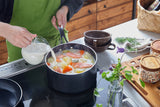 Kyocera ceramic black cooking pot showing its sleek, durable ceramic surface and sturdy handles for versatile kitchen use.