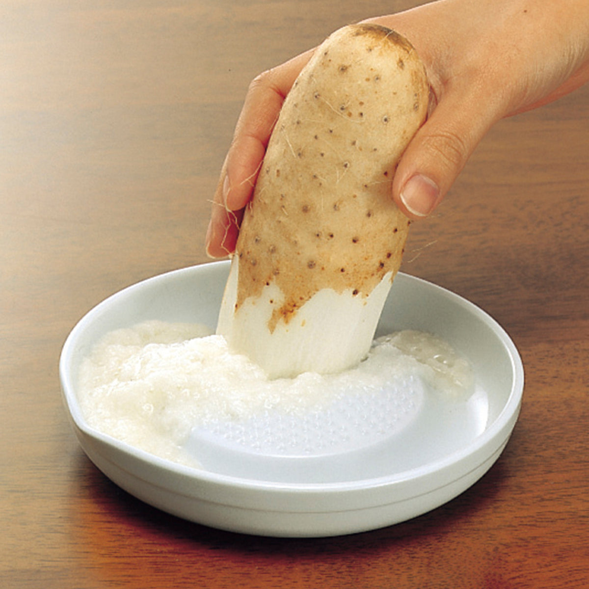 White KYOCERA ceramic grater with a sleek design, suitable for grating cheese, vegetables, and spices.