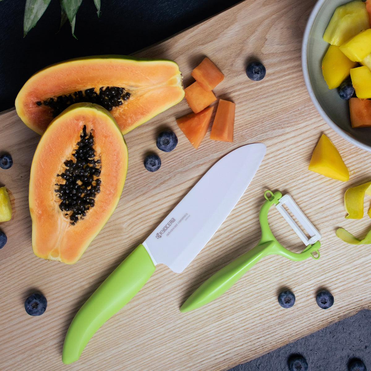 KYOCERA double-sided vegetable peeler with green handle and sharp dual-blade design for efficient peeling.