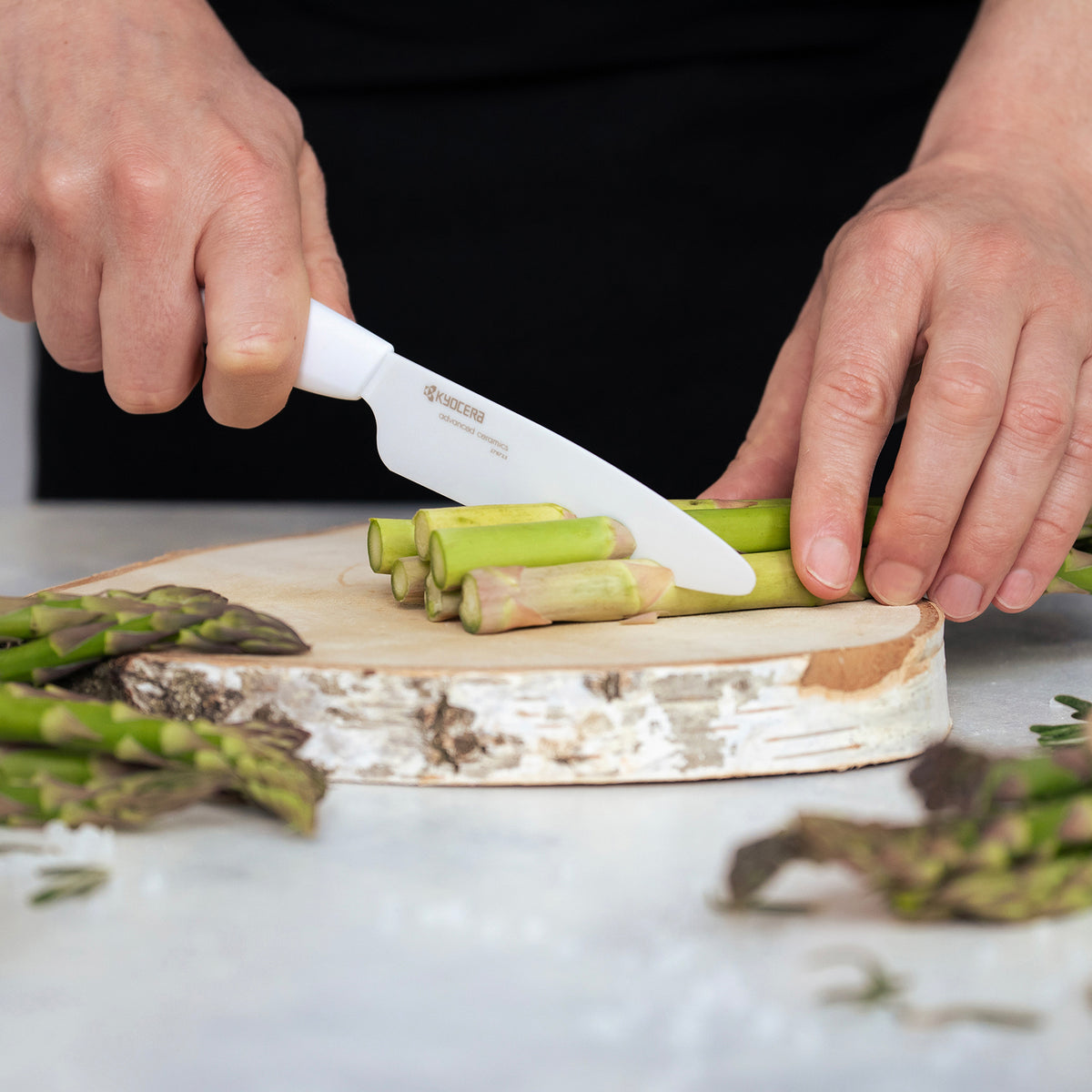 KYOCERA ceramic paring knife with white handle and blade, designed for precise cutting and kitchen prep.