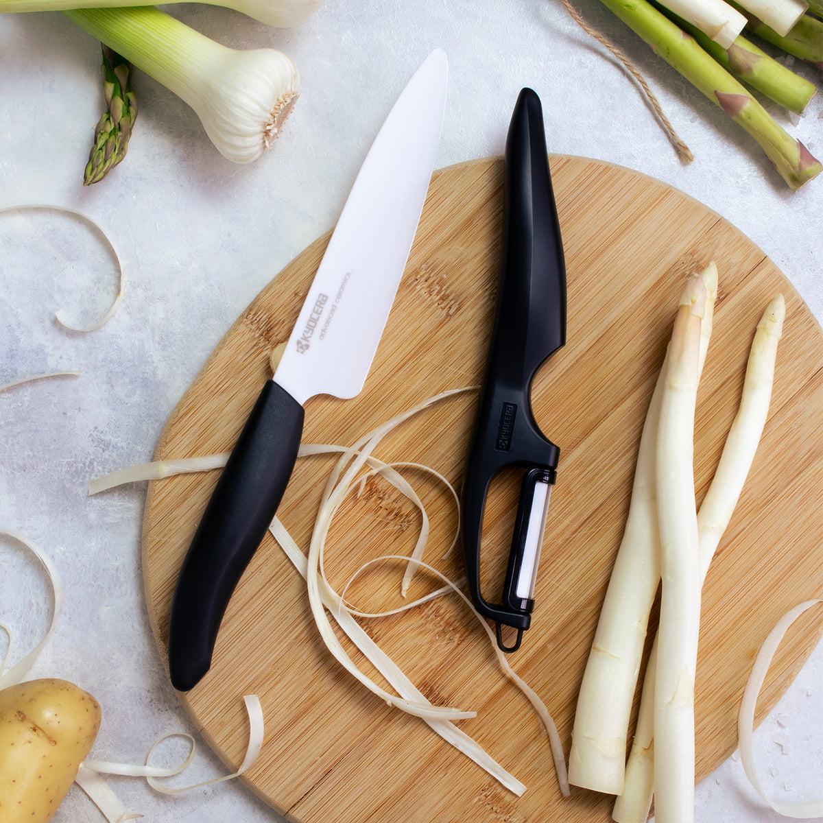 KYOCERA double-sided vegetable peeler with sharp blades, ergonomic handle, and stainless steel construction for efficient peeling.