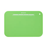 Flexible black KYOCERA cutting mat, 37 x 25 cm, used for safe and precise slicing on various surfaces.