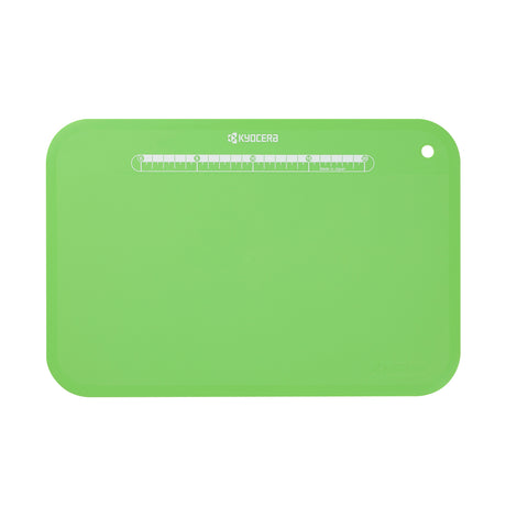 Flexible black KYOCERA cutting mat, 37 x 25 cm, used for safe and precise slicing on various surfaces.