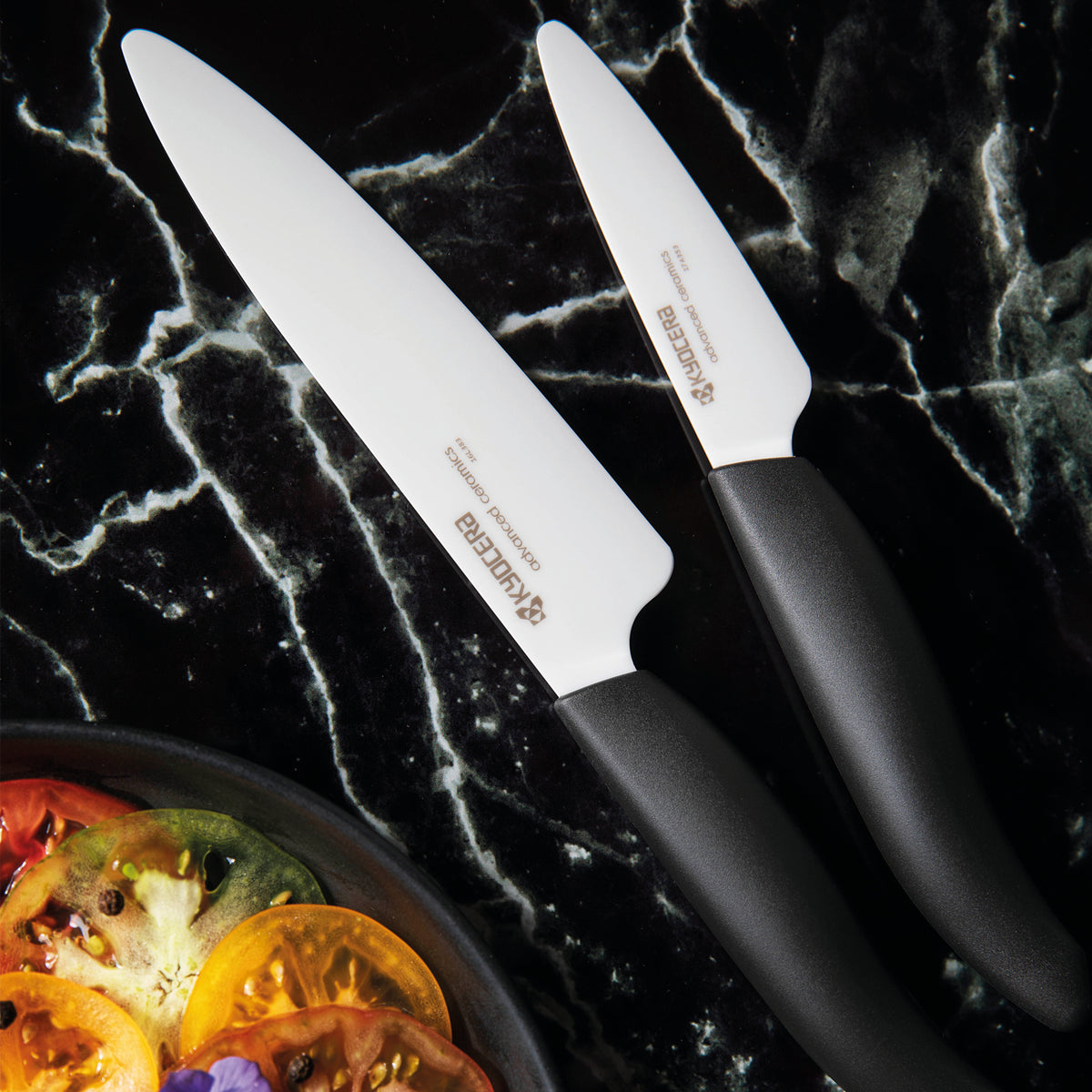 KYOCERA ceramic knife set with three black knives on a white background, showcasing sleek, sharp blades and ergonomic handles.