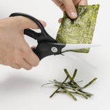 KYOCERA ceramic kitchen scissors in black and white with durable handles, ideal for precise cutting in the kitchen.