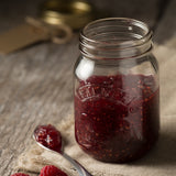 Clear Kilner screw-top canning jar with glass body, ideal for preserving fruits and vegetables.