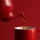 Red P & K Kensington teapot from Price & Kensington with 10 cups, traditional ceramic tea set on a white background.