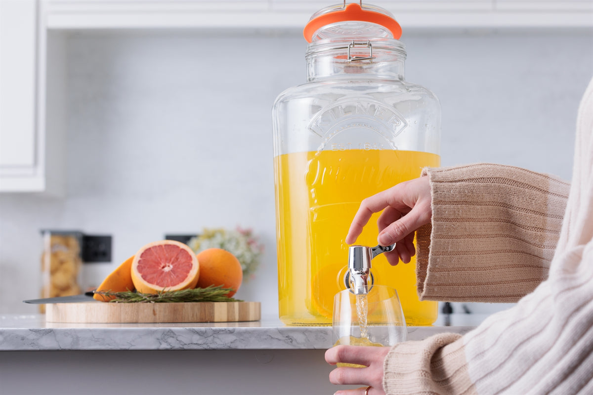 Clear 8L Kilner drink dispenser with round shape and spigot, made of glass, perfect for serving beverages at gatherings.