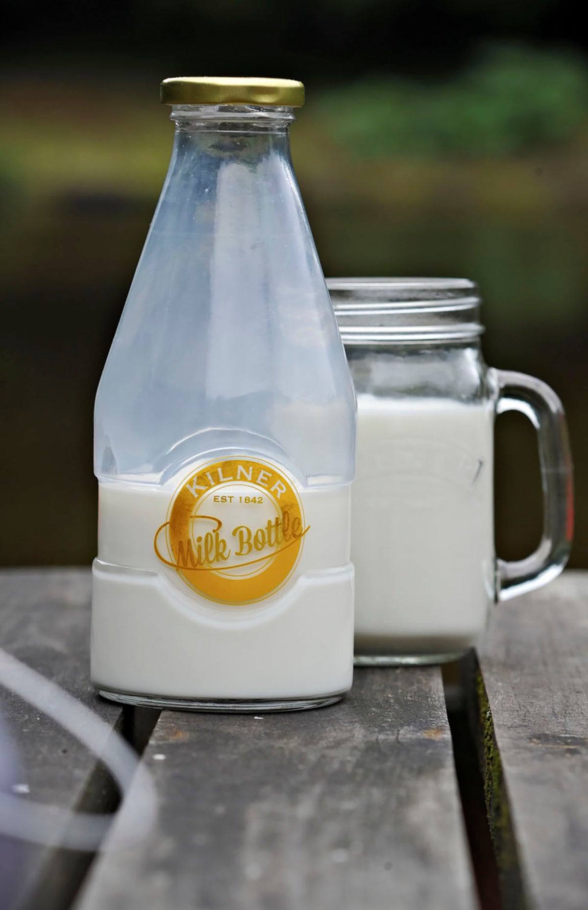 KILNER glass milk bottle with a clear, cylindrical design and a metal screw cap for storing and serving fresh milk.
