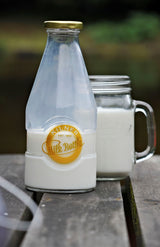 KILNER glass milk bottle with a clear, cylindrical design and a metal screw cap for storing and serving fresh milk.
