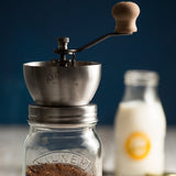 KILNER manual coffee grinder with crank handle, clear glass body, and 500 ml capacity for fresh coffee beans.