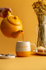 Yellow P & K Teekanne teapot with a sleek, modern design, featuring a smooth surface and curved spout.