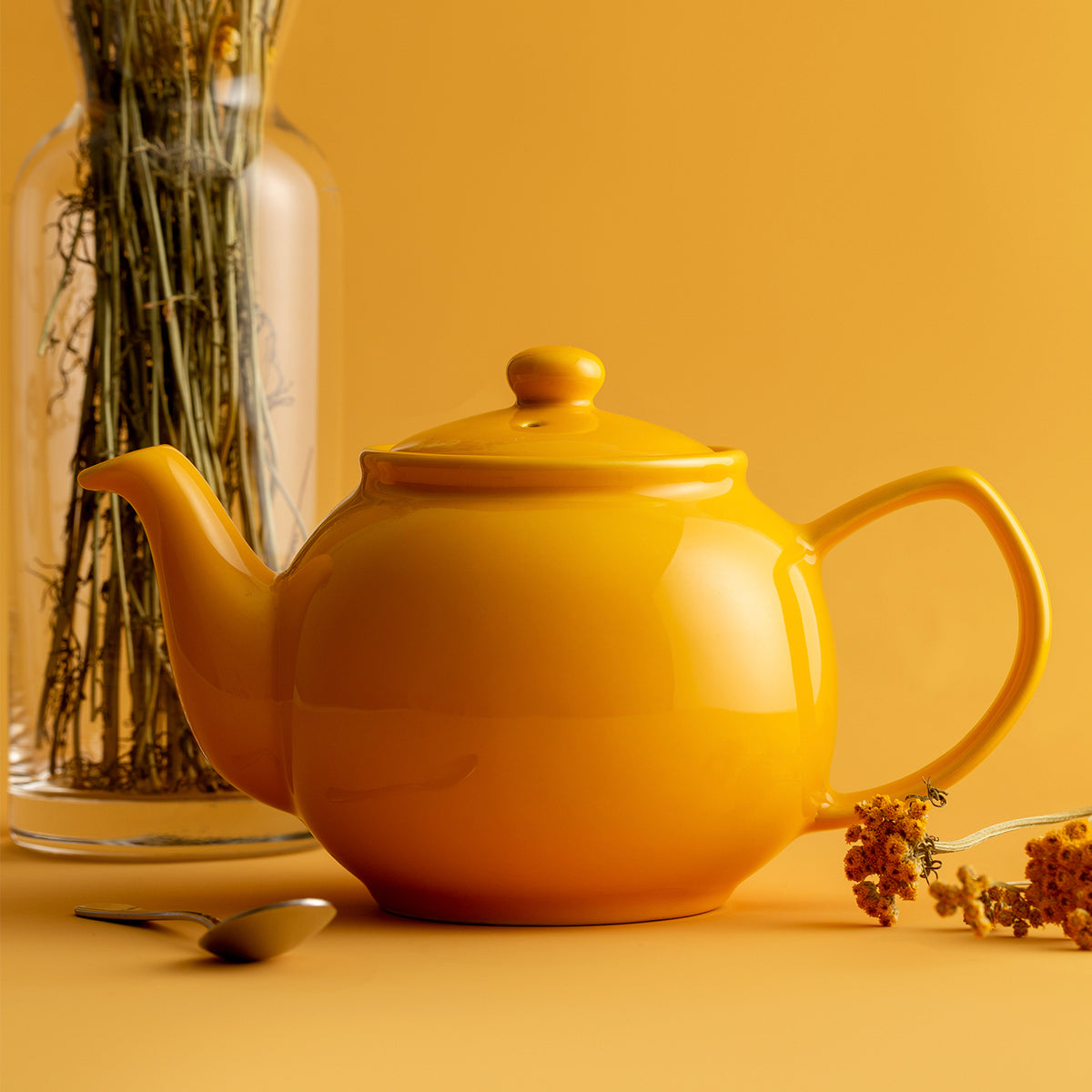 Yellow P & K Teekanne teapot with a smooth, rounded design, featuring a curved handle and spout, on a neutral background.