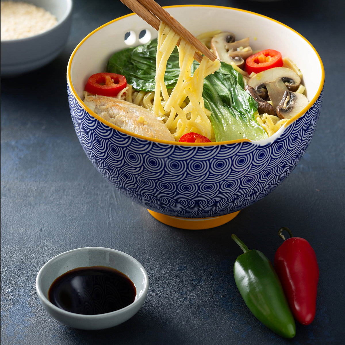 Blue TYPHOON Asian noodle bowl with chopsticks, round shape, perfect for serving noodles and Asian cuisine.