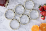 KILNER replacement parts for canning jars, including lids and seals, in a close-up image showing various jar components.