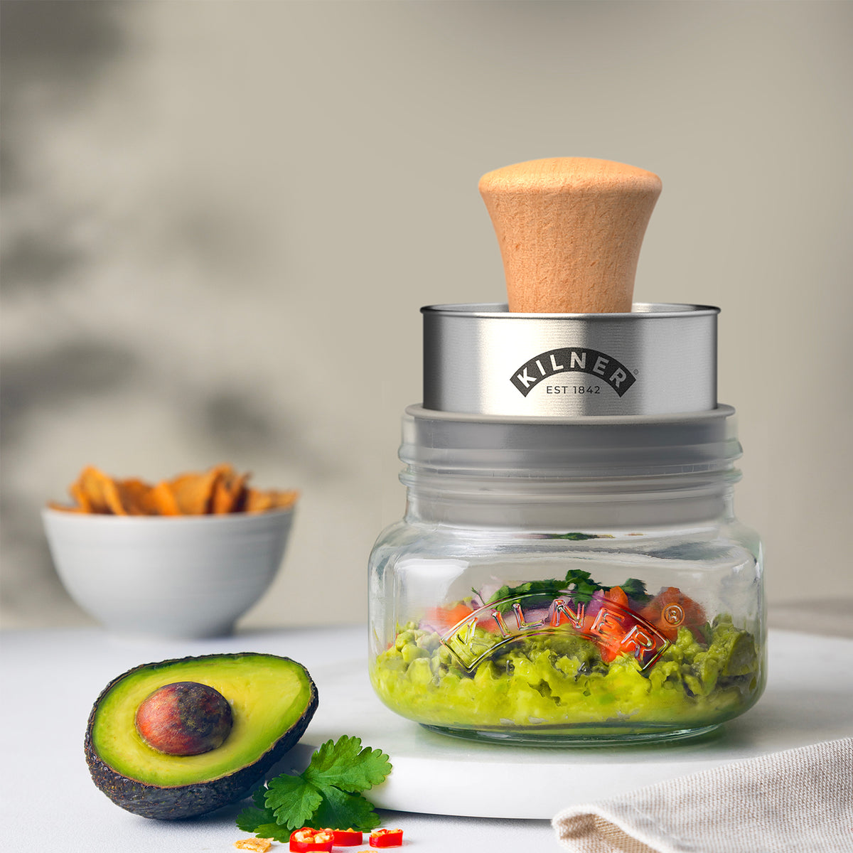 KILNER Gucamole-Set in clear 500 ml jar with fresh guacamole and serving utensils on a wooden surface.