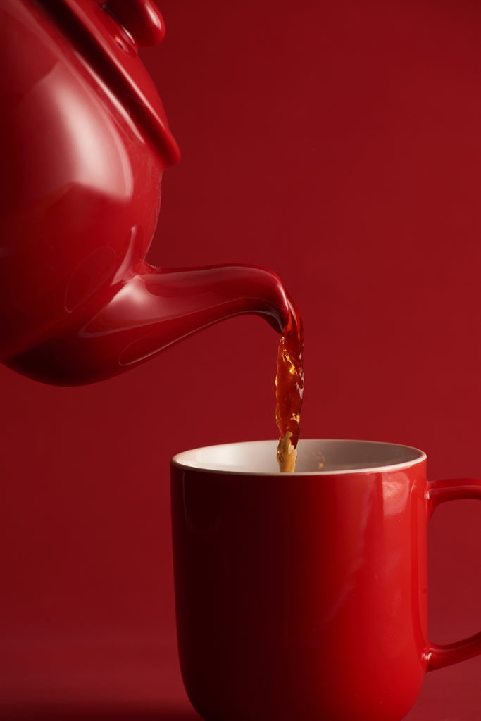 Red P & K teapot with built-in infuser and six matching cups, perfect for brewing and serving tea.