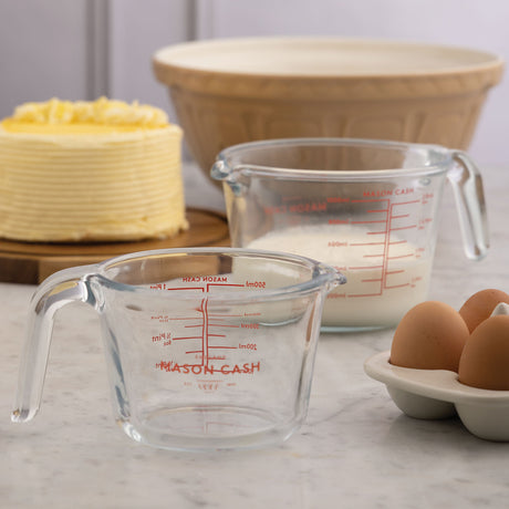 Clear Mason Cash classic measuring jug with measurement markings and a sturdy handle for precise liquid measurement.
