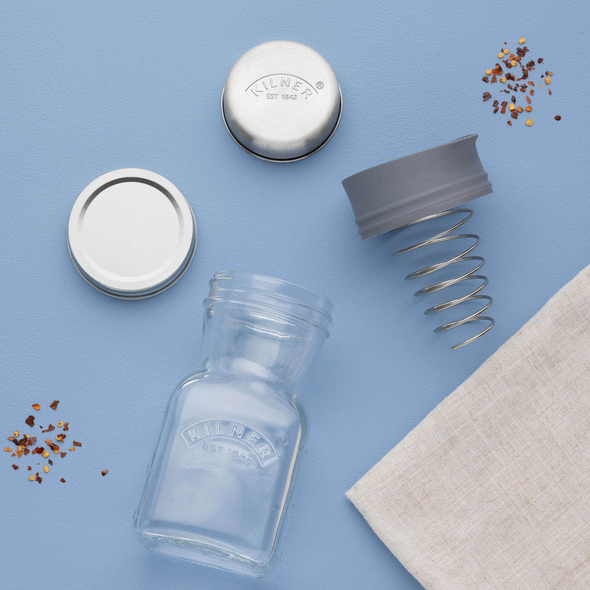 KILNER clear 500 ml dressing shaker with measurements and lid, used for mixing and pouring salad dressings or sauces.