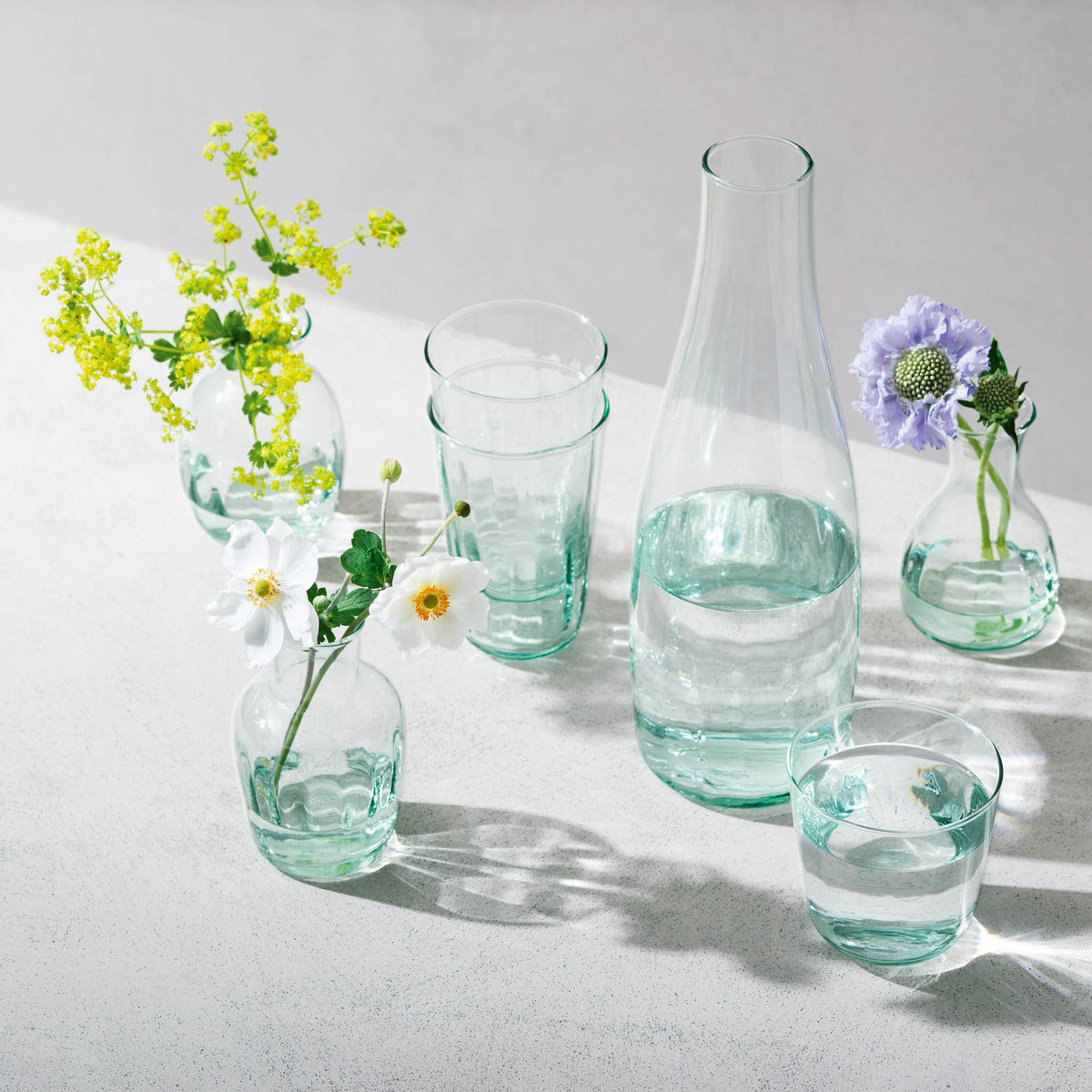 Set of four LSA Mia 250ml recycled glass tumblers with optically designed patterns, perfect for stylish drinking.
