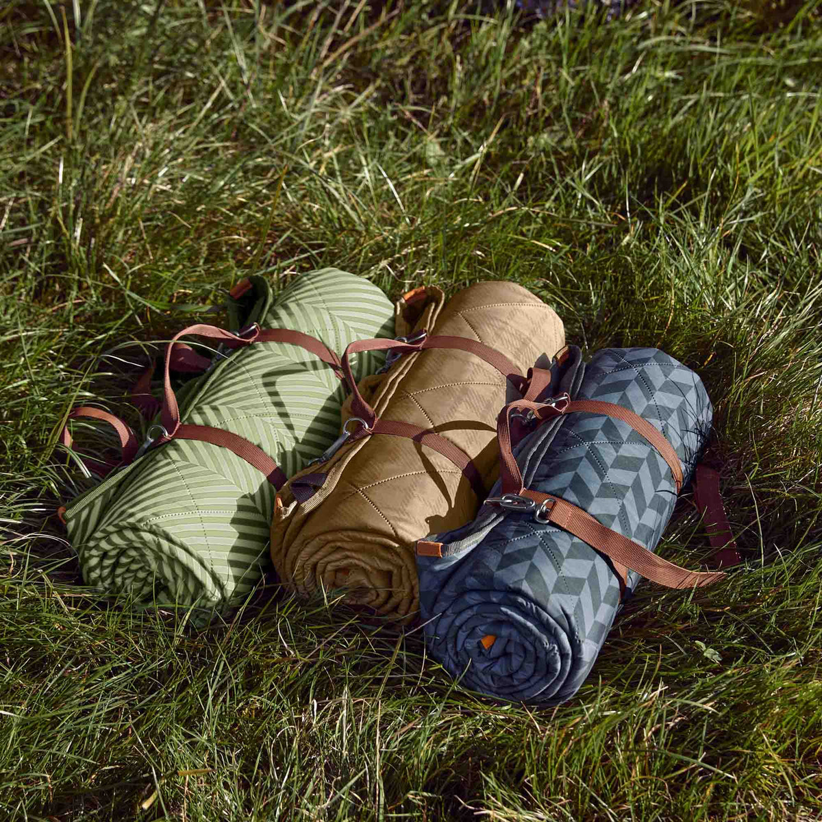 Green BLACK+BLUM picnic blanket, 2 x 1.4 meters, spread out on grass with a foldable design and soft fabric surface.