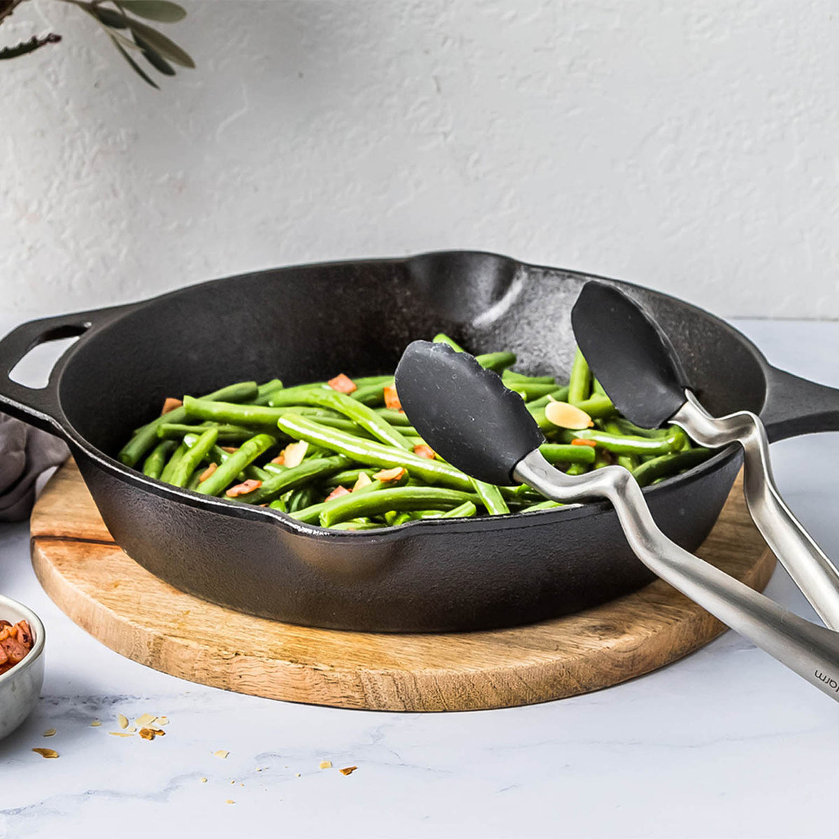 DREAMFARM black kitchen tongs, CLONGS style, stainless steel kitchen utensil for grilling and cooking, close-up image.
