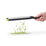 DREAMFARM green fine and concave kitchen grater, OZEST brand, showing textured surface for grating vegetables and cheese.